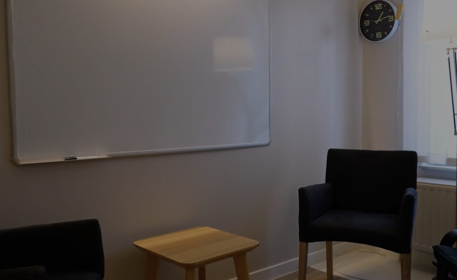 Cabinet de consultation du Centre Médical « Le Lotus » : fauteuils, tableau blanc et horloge